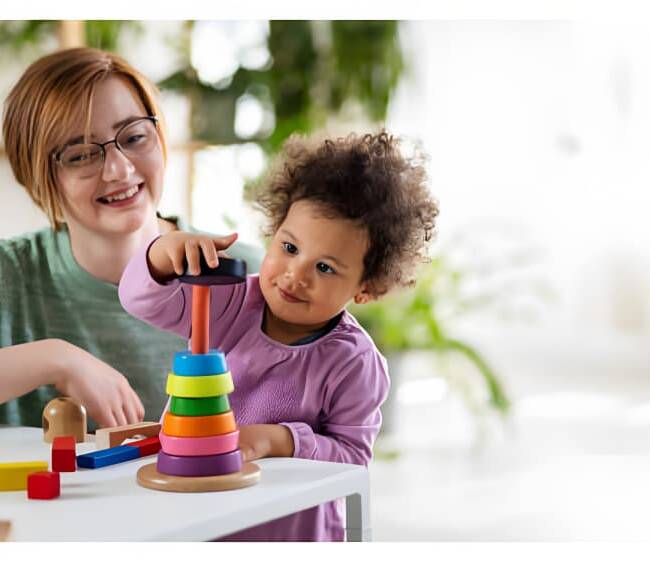 A care worker is playing with a baby