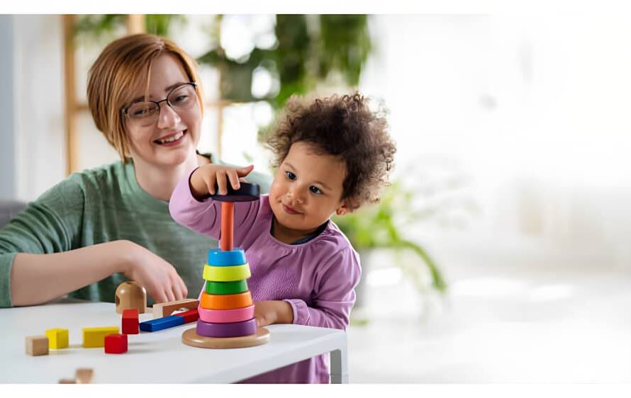 A care worker is playing with a baby