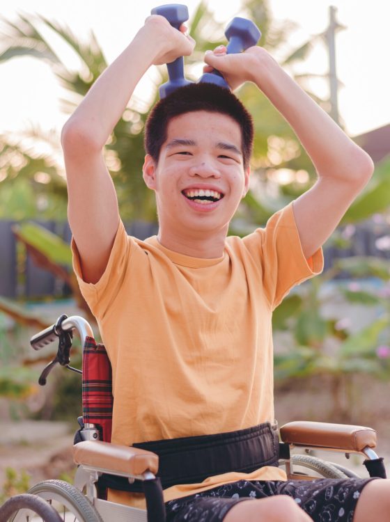Young man with disability happy face with exercising by using both arm muscles lifting dumbbells in outdoor garden of home,hospital,nursery, Health physical therapy and rehabilitation concept.