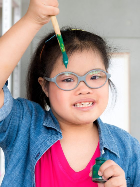 Portrait of young Asian autism disabled child complex genetic disorders girl draw a picture with watercolor in element classroom.